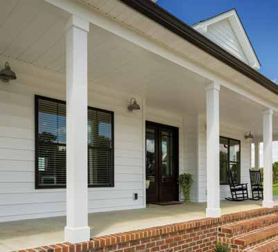 White farmhouse porch with black-framed windows and door, sided in CertainTeed MainStreet Single 8-inch Clapboard in Colonial White